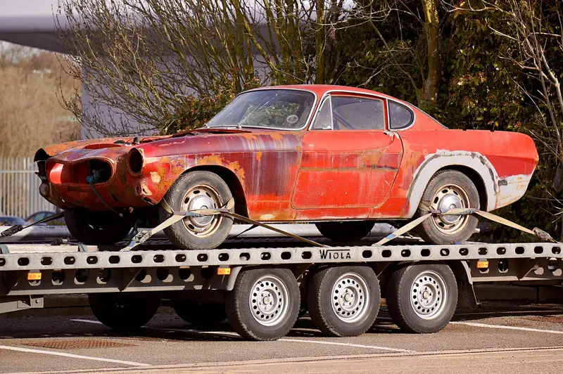 A coupe secured on a flatbed trailer