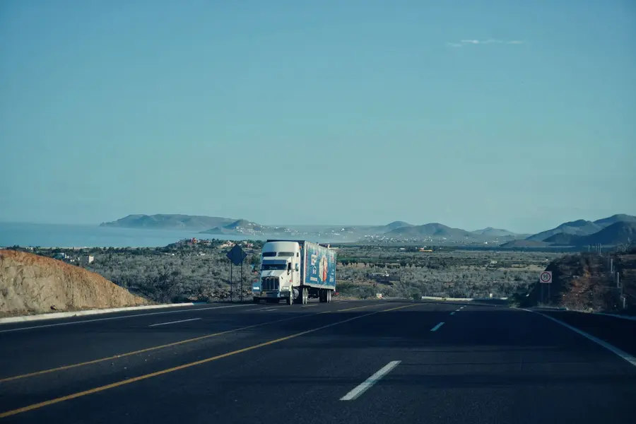 A freight truck moving along a scenic coastal highway
